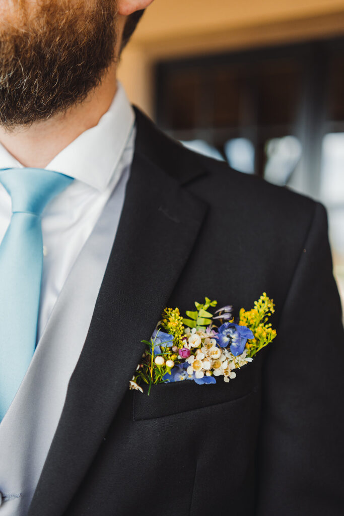 spring groom wearing blue and yellow boutonniere