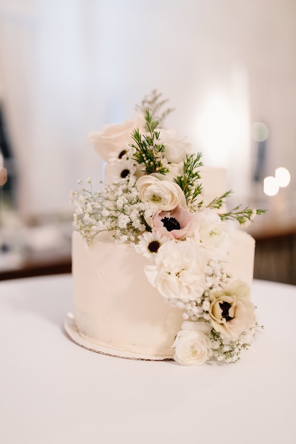 White and black flowers on white wedding cake at wedding reception